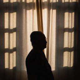 A silhouette of a man indoors by a window.