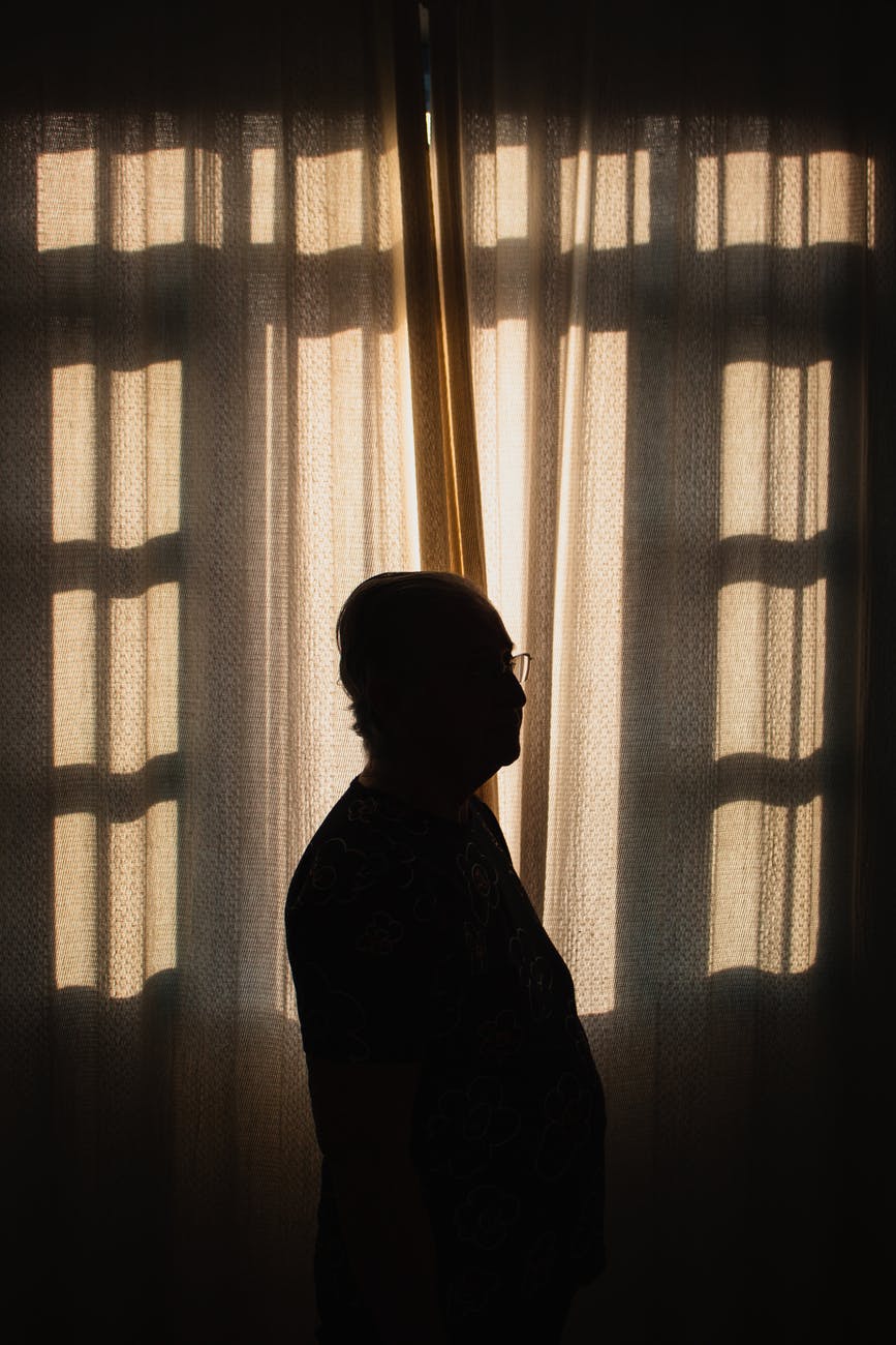 A silhouette of a man indoors by a window.