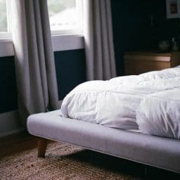 The edge of a bed with a mattress.